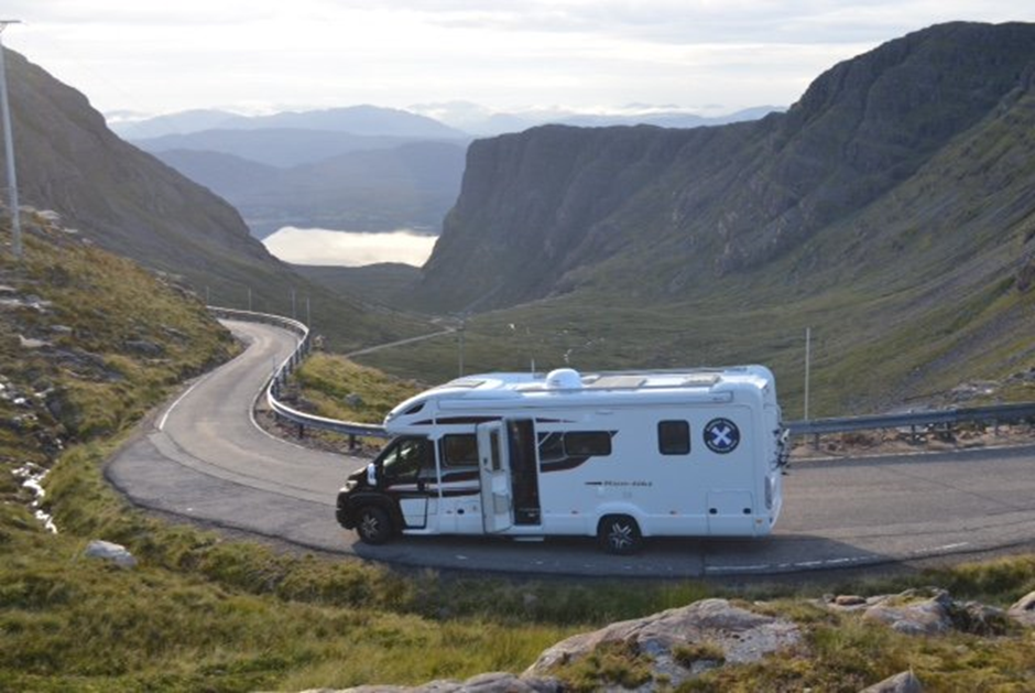 scottish tourer motorhome driving on empty road in scotland 