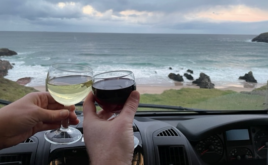 View from motorhome window at sango sands with wine glasses giving a cheers