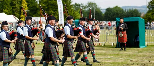 Pipe band playing at Highland Games/ scottish Tourer Motorohme hire